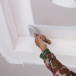 hand of worker using gypsum plaster ceiling joints