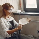 A young woman makes dishes in a pottery