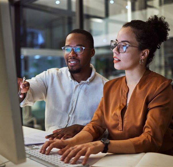 Employees working in the office, looking at computer screen