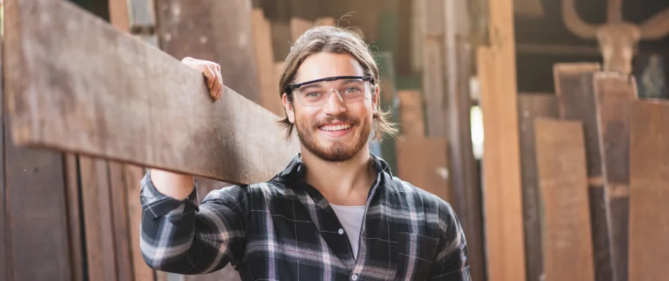 A carpenter carrying timber