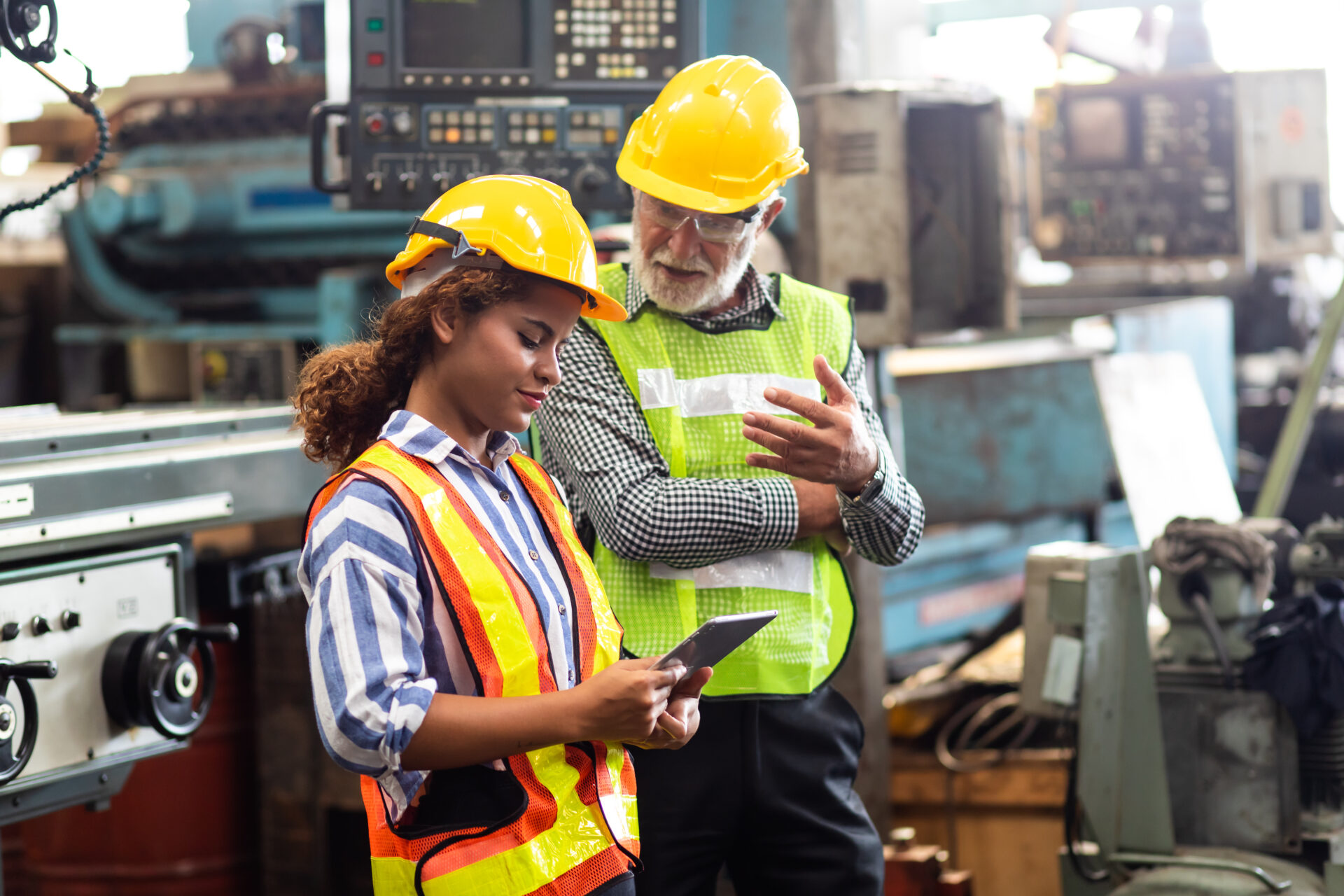 Professional tradespeople working at industrial manufacturing factory.