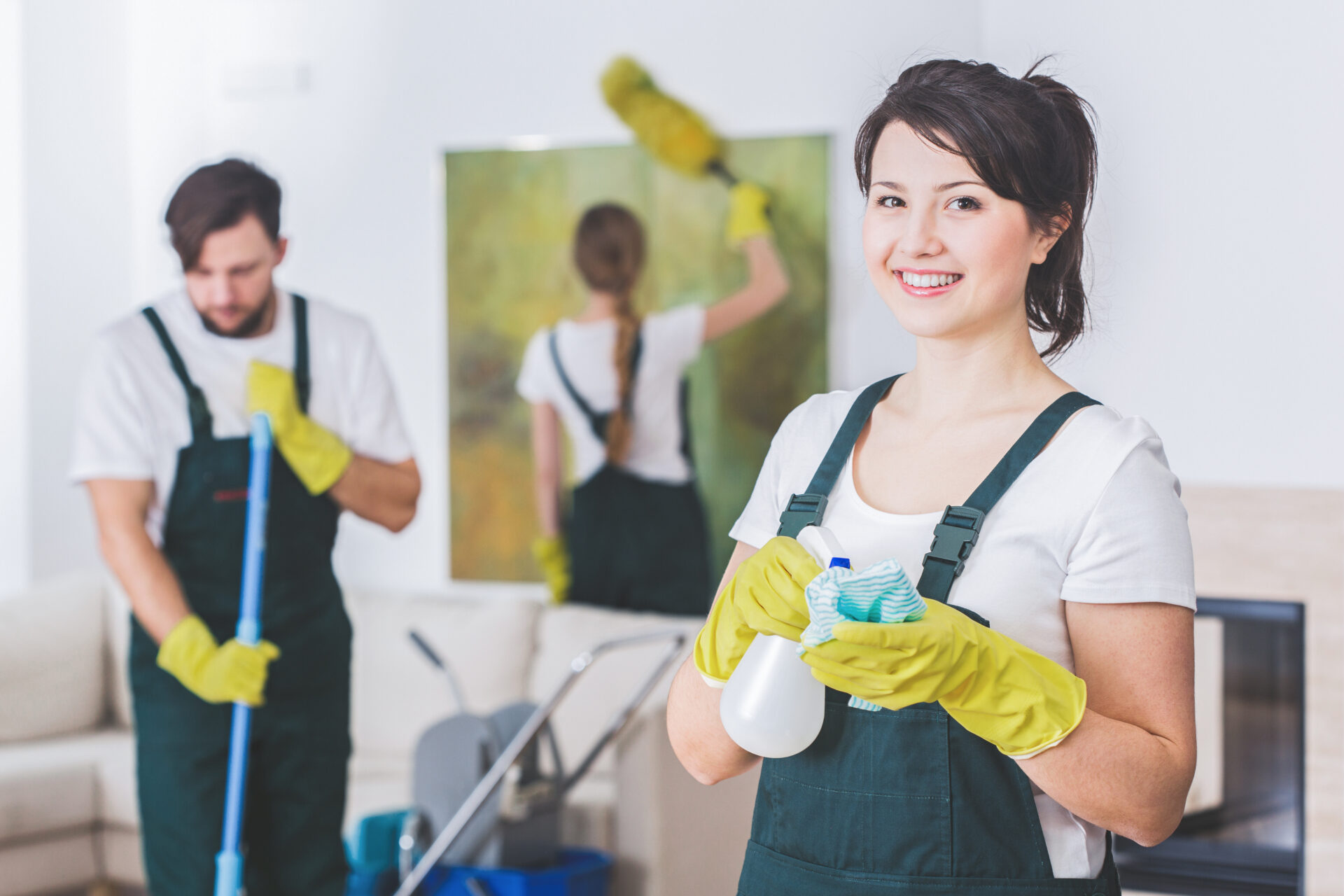 Professional cleaners in apartment with cleaning solution and supplies