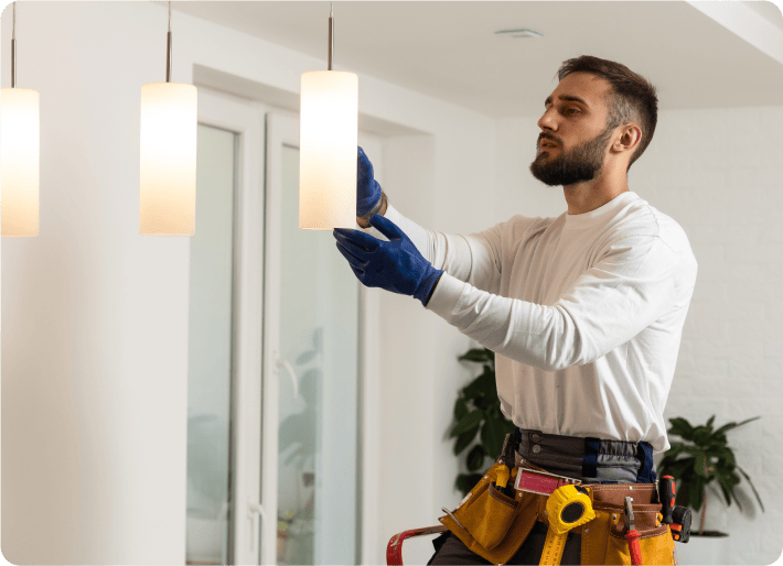 An electrician installing lights