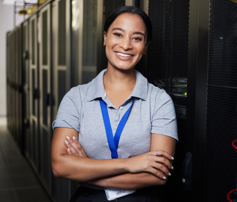 An IT woman in a server room, with computer servers and equipment.