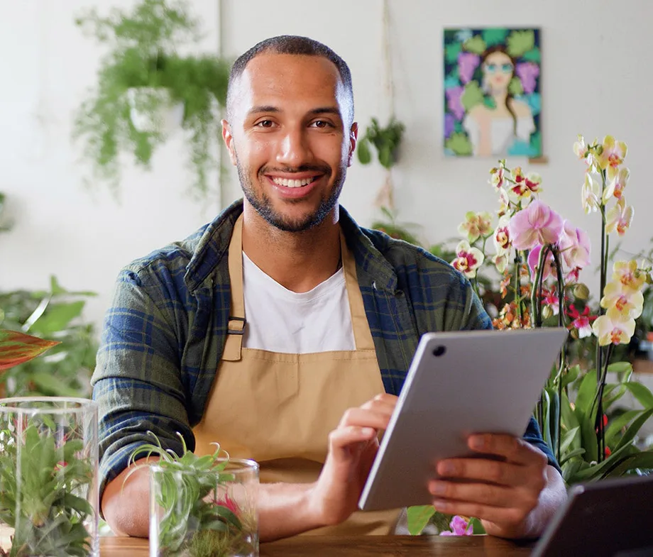 A flower shop owner with a device