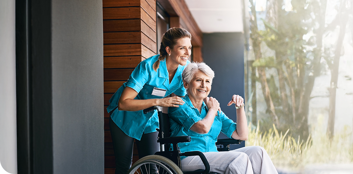 A woman in a wheelchair is assisted by a support worker, showcasing support and care.  