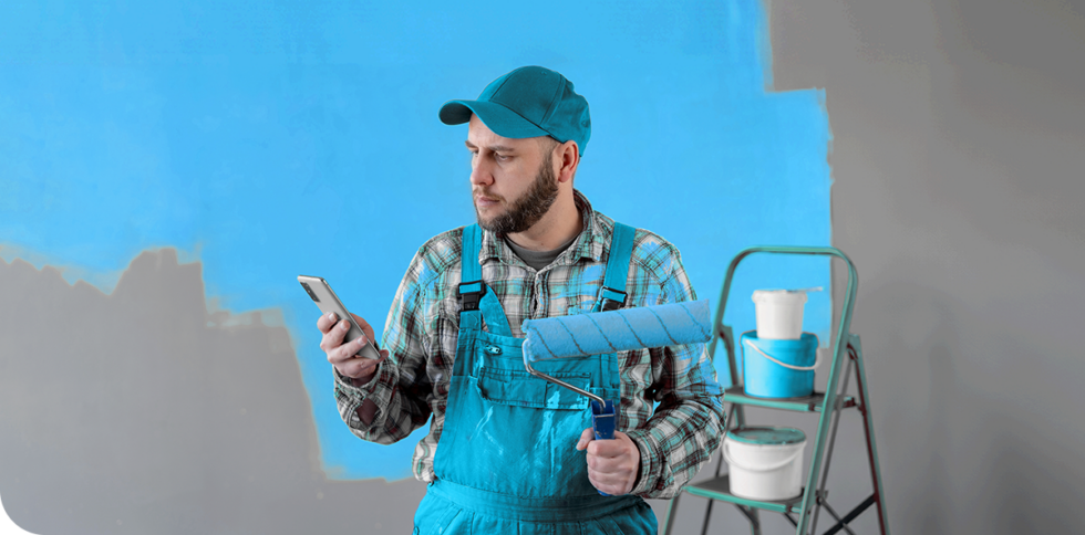 A sole trader with a paint roller, preparing to start painting.