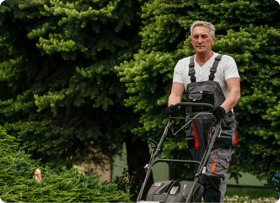 A garden specialist mowing garden with a machine