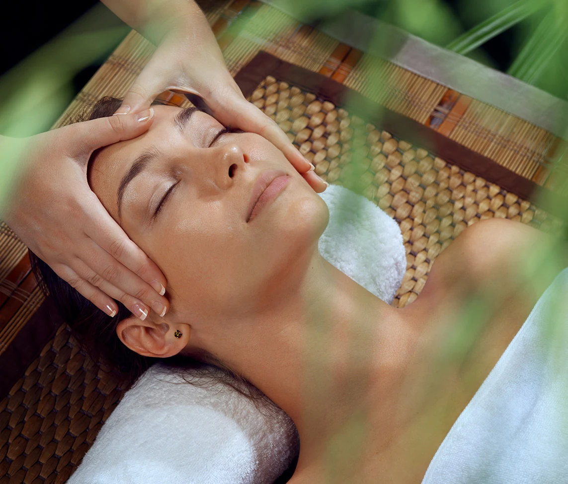 A natural therapist treating a patient with facial treatment