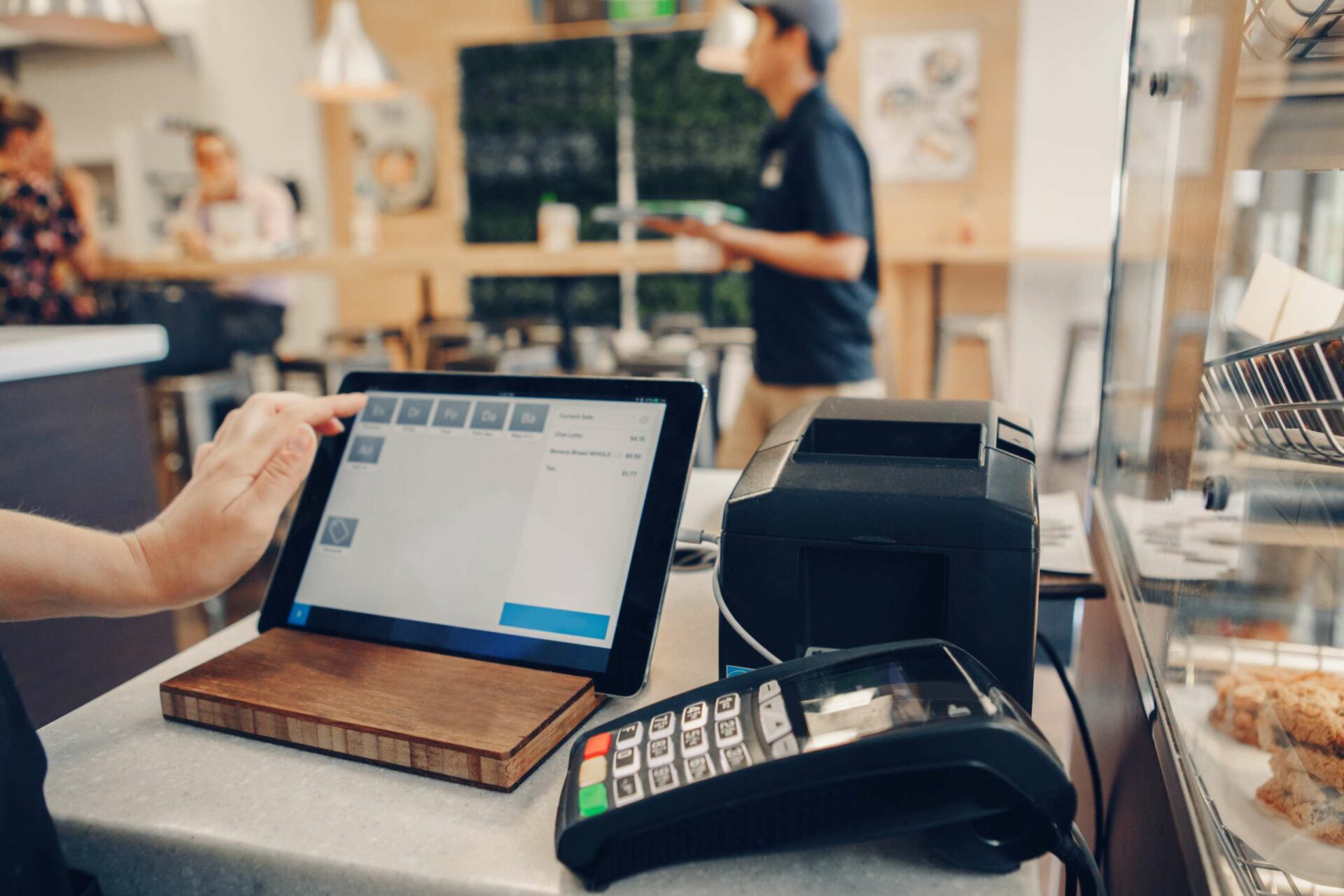 Closeup shot of cashier hands. Seller using touch pad for accepting client customer payment.