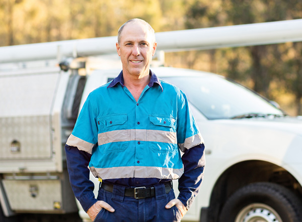 A tradesman working on job site next to a commercial vehicle