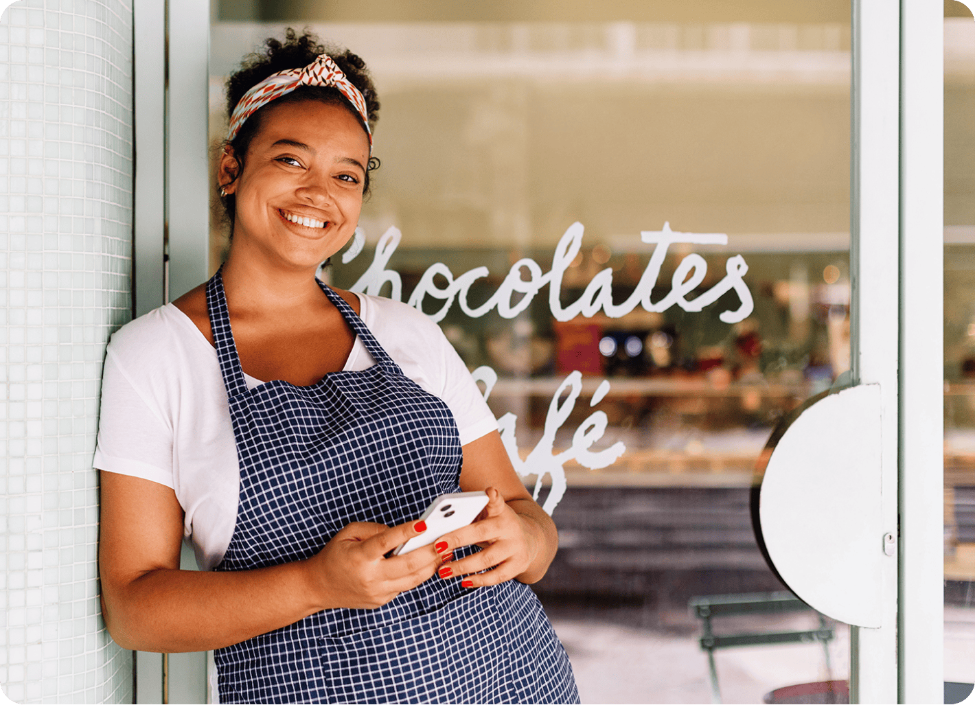 A happy business owner in front of a glass door