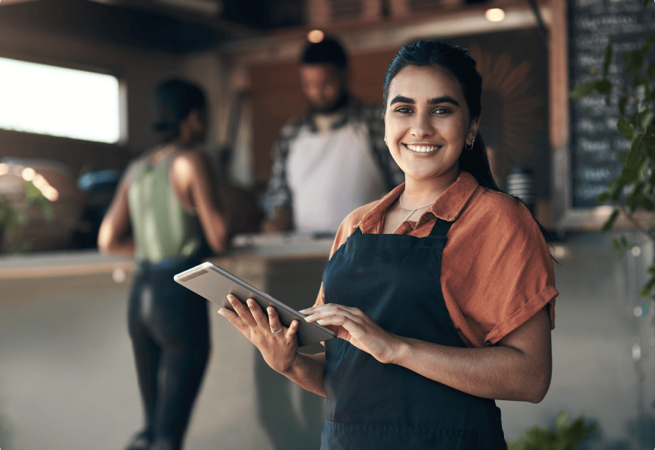 A food business owner holds a tablet computer